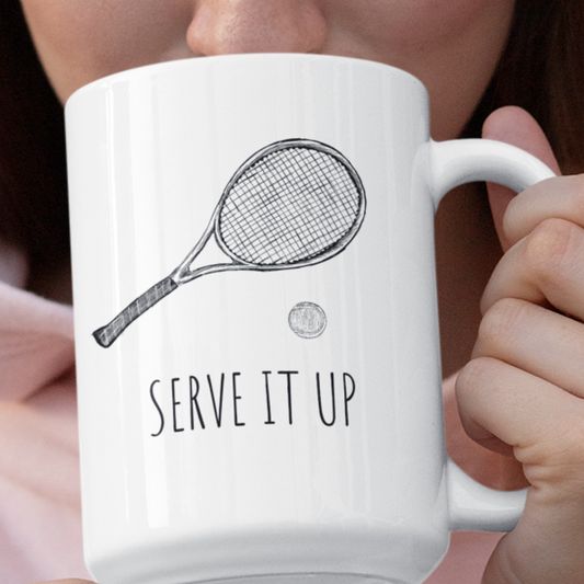 15oz coffee mug featuring a tennis racket and ball illustration with the text "Serve it Up," held by a model. Ideal gift for tennis players, coaches, and fans who love tennis-themed drinkware.