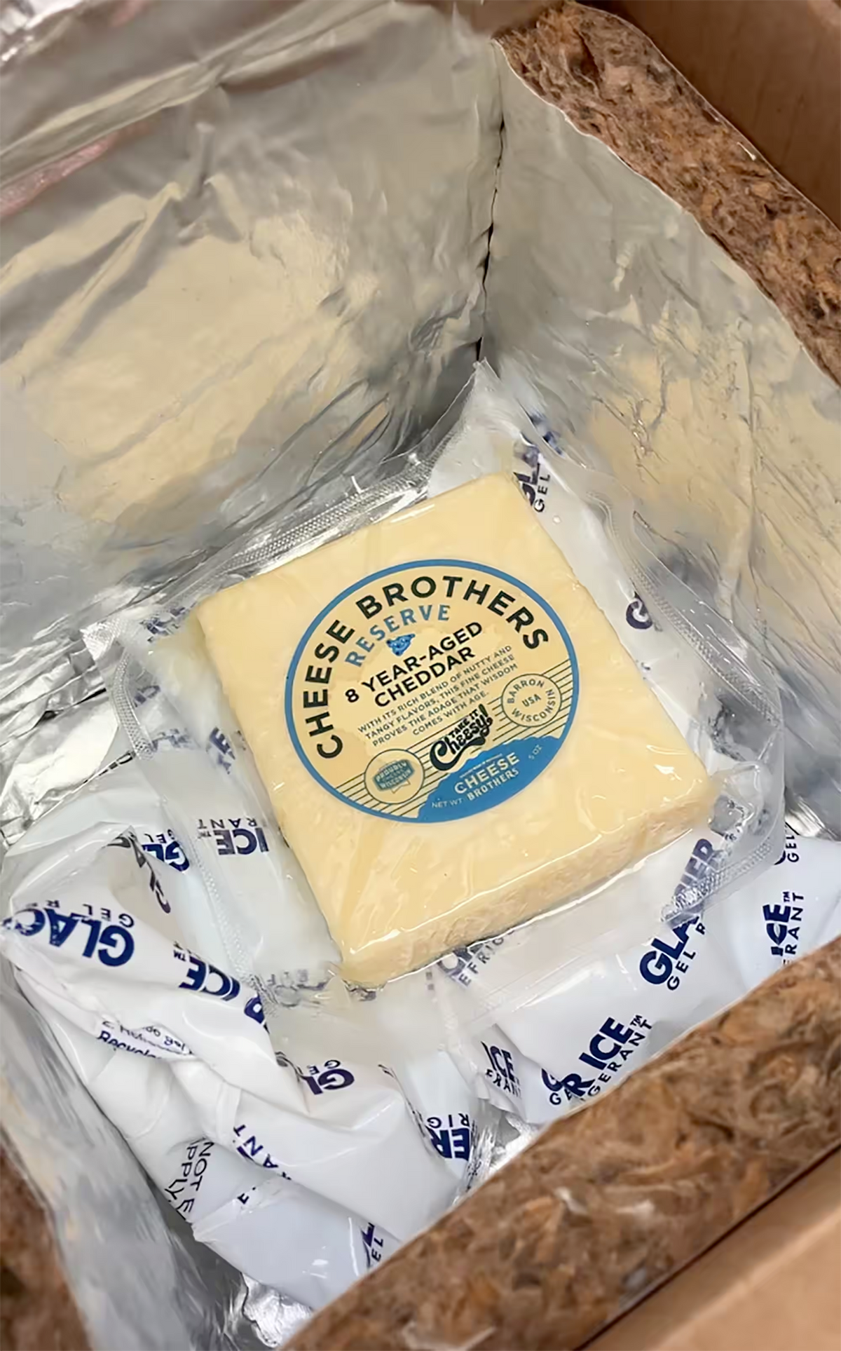A Cheese Brothers shipping box inside showing how the Cheese Brothers ship their cheeses. The box is insulated and equipped with cold packs to temperature control the cheese.