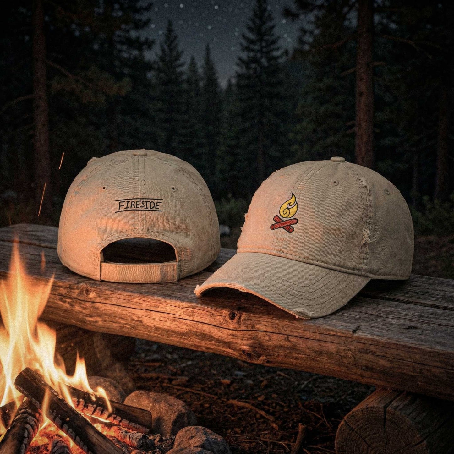 Two beige 100 percent cotton twill caps with Fireside embroidered graphics on a log in front of a campfire at night by Kempain Family Outfitters.