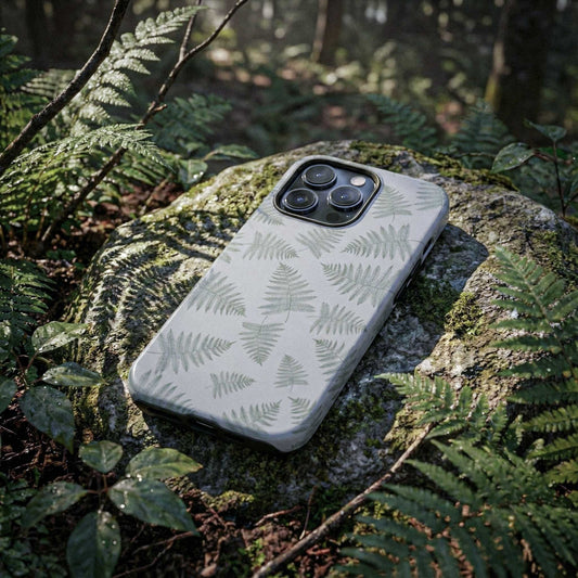 Phone case with fern pattern on a rock surrounded by greenery