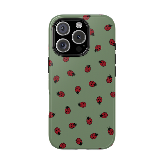 An iPhone 16 sporting a unique Lady Bug pattern case designed and illustrated by Kempain Family Outfitters on a white background.
