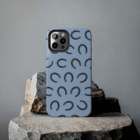 Lucky Horseshoe Phone Case displayed on a rock, showcasing its durable design and stylish equestrian-themed lucky charm pattern.