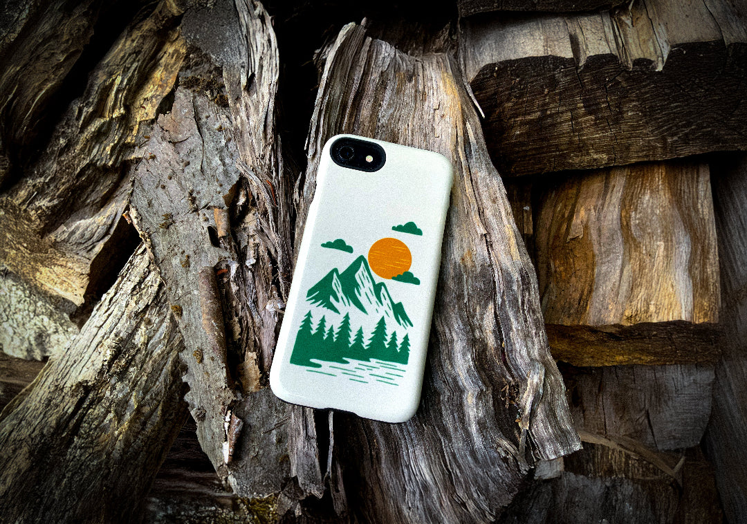iPhone 7 case with mountain and tree design on a wooden background