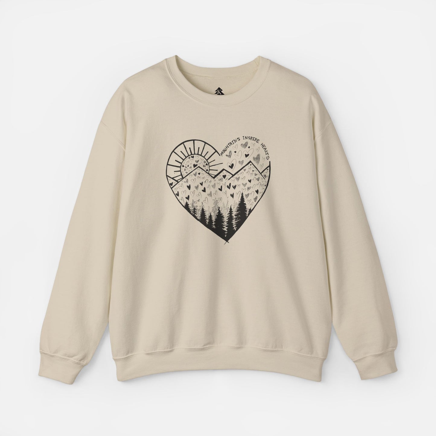 A sand color crewneck sweatshirt featuring a heart-shaped mountain design with the text and Mountains Inspire Hearts, perfect for anyone that loves hiking, mountain views, or the outdoors.
