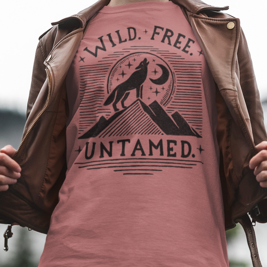 Model wearing Wild. Free. Untamed. Wolf Howling Tee, featuring a majestic wolf howling at the moon with handwritten text, perfect for nature lovers and adventure seekers.