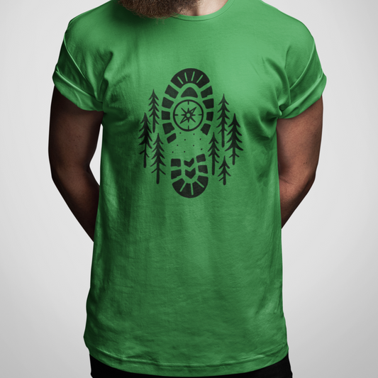 Boot Print Compass Forest T-Shirt worn by model on gray background, showcasing rugged hiking design for nature lovers.