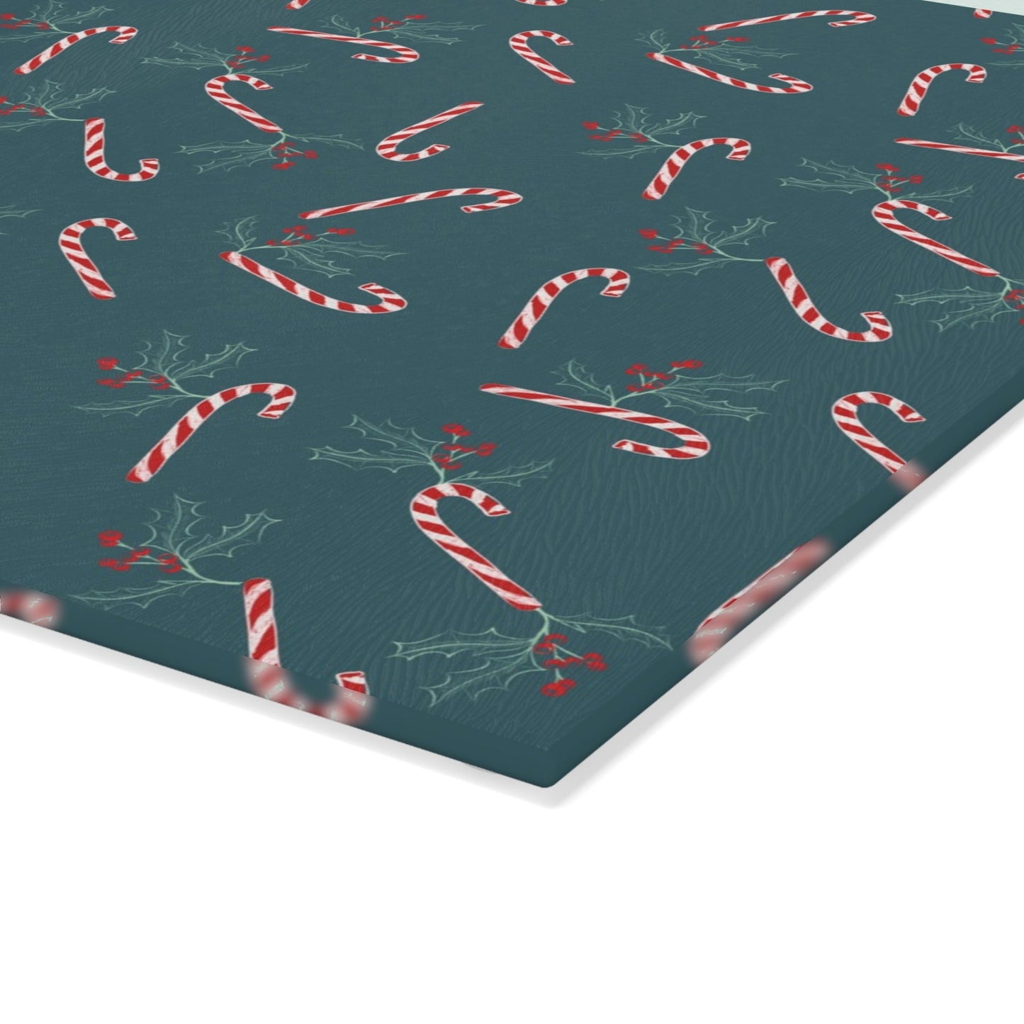 Close-up view of a glass cutting board featuring a candy cane and holly pattern, displayed on a white background, highlighting the vibrant holiday design details.