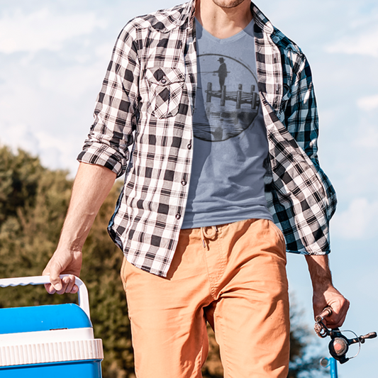 Model wearing blue Fisherman Dockside Tee, featuring a geometric illustration of a fisherman on a dock, perfect for anglers and outdoor enthusiasts.