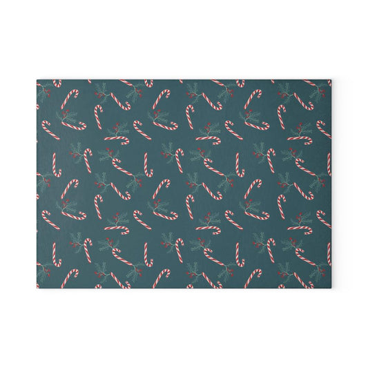 Front view of a glass cutting board featuring a candy cane and holly pattern, displayed straight on against a white background, highlighting its festive holiday design.