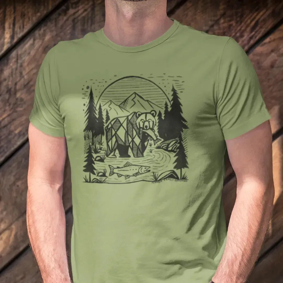 Model wearing Geometric Bear & Salmon T-Shirt, featuring a bold geometric bear catching a salmon with a mountain river and pine trees, perfect for outdoor and wildlife enthusiasts.