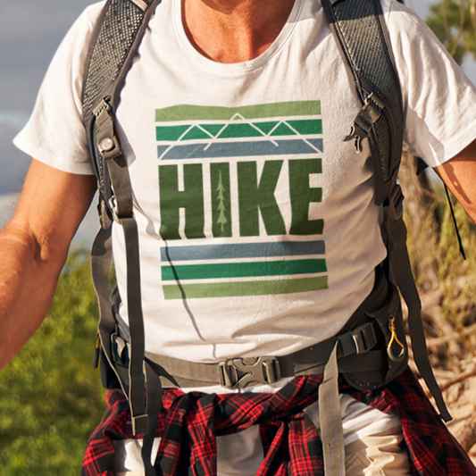 Model wearing Hike Mountain Graphic T-Shirt while hiking, showcasing the bold adventure-inspired design with a mountain and tree graphic inside the letter 'I'.