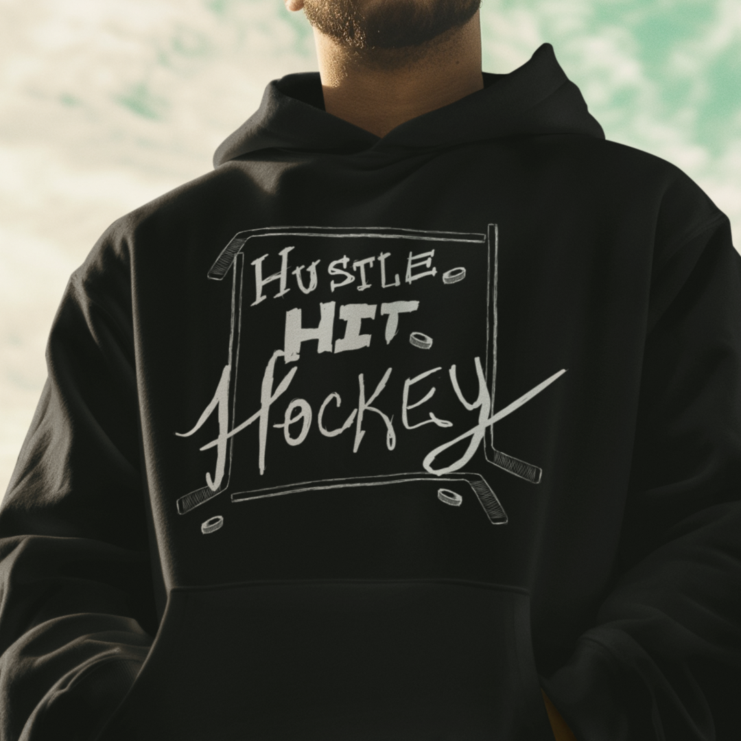 Model wearing a black Hustle Hit Hockey Hoodie with bold hockey-themed design, showcasing comfort and style for hockey fans.