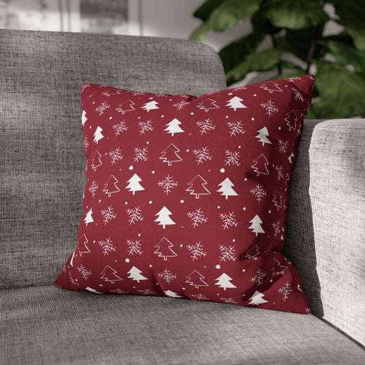 Lifestyle view of a red pillow case featuring a winter snowflake and tree pattern, placed on a couch, adding a festive and cozy touch to the living room decor.