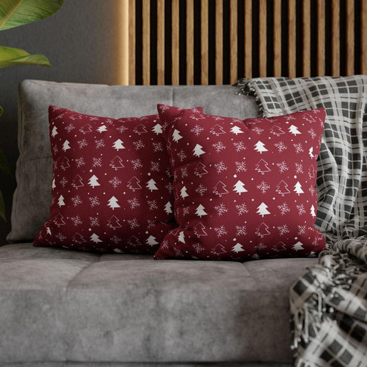 Lifestyle view of two red pillow cases featuring a winter snowflake and tree pattern, placed on a couch, enhancing the festive and cozy atmosphere of the living room.