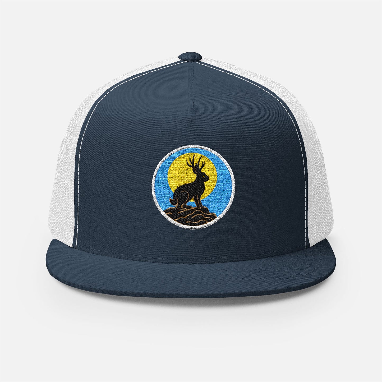 Front view of navy/white trucker cap featuring embroidered jackalope silhouette and moonrise design in white thread.