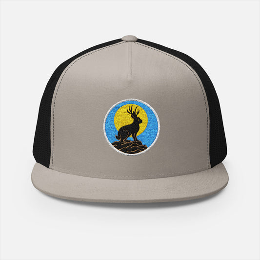 Front view of silver/black trucker cap featuring embroidered jackalope silhouette and moonrise design in white thread.
