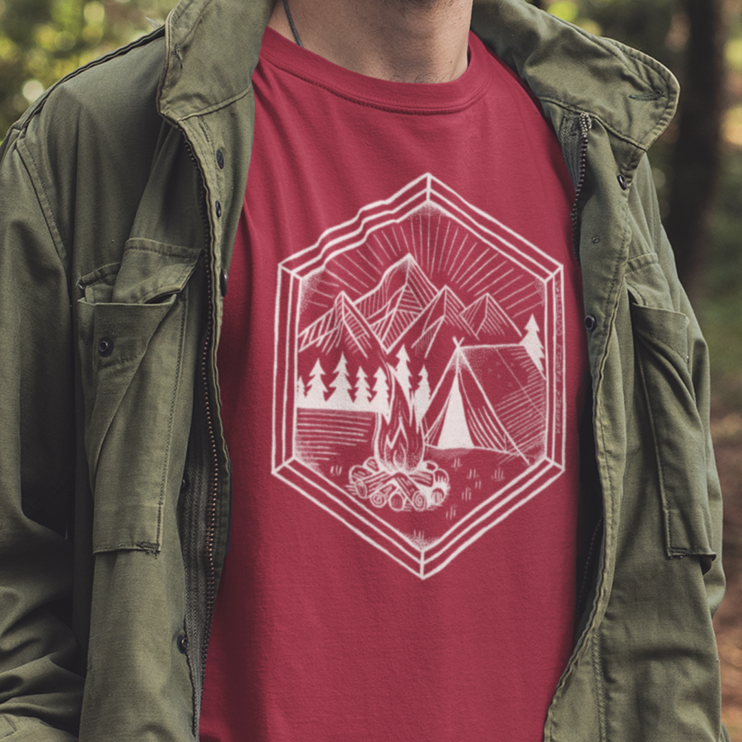 Nature’s Refuge Geometric Camping T-Shirt worn by a model, featuring a cozy tent, glowing campfire, and pine trees—perfect for outdoor adventurers and campers.