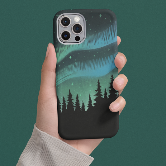 Northern Lights Pine Tree Phone Case held by hand on solid green background, showcasing mystical forest and glowing night sky design design of the iPhone case.