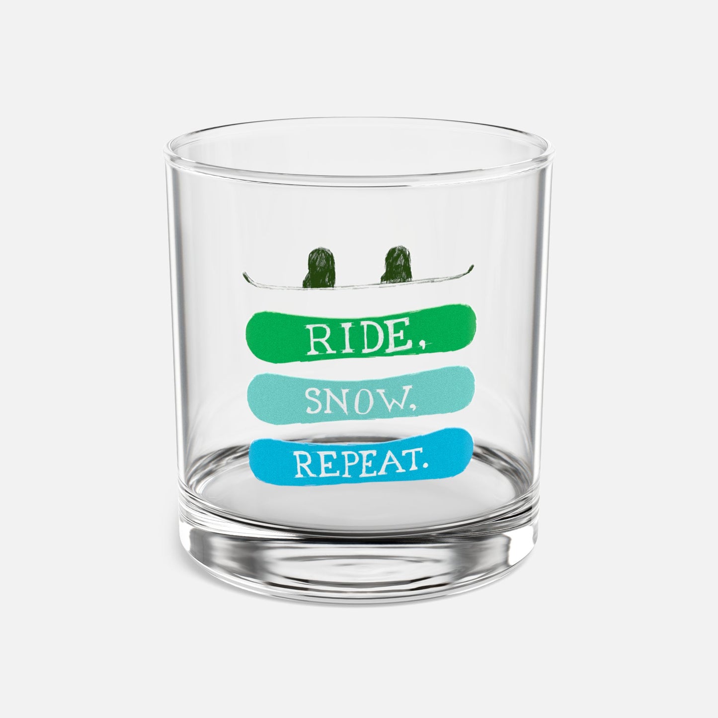 Rocks glass with the phrase 'Ride, Snow, Repeat' and a snowboarding-themed design, displayed on a clean white background, ideal for showcasing stylish drinkware.