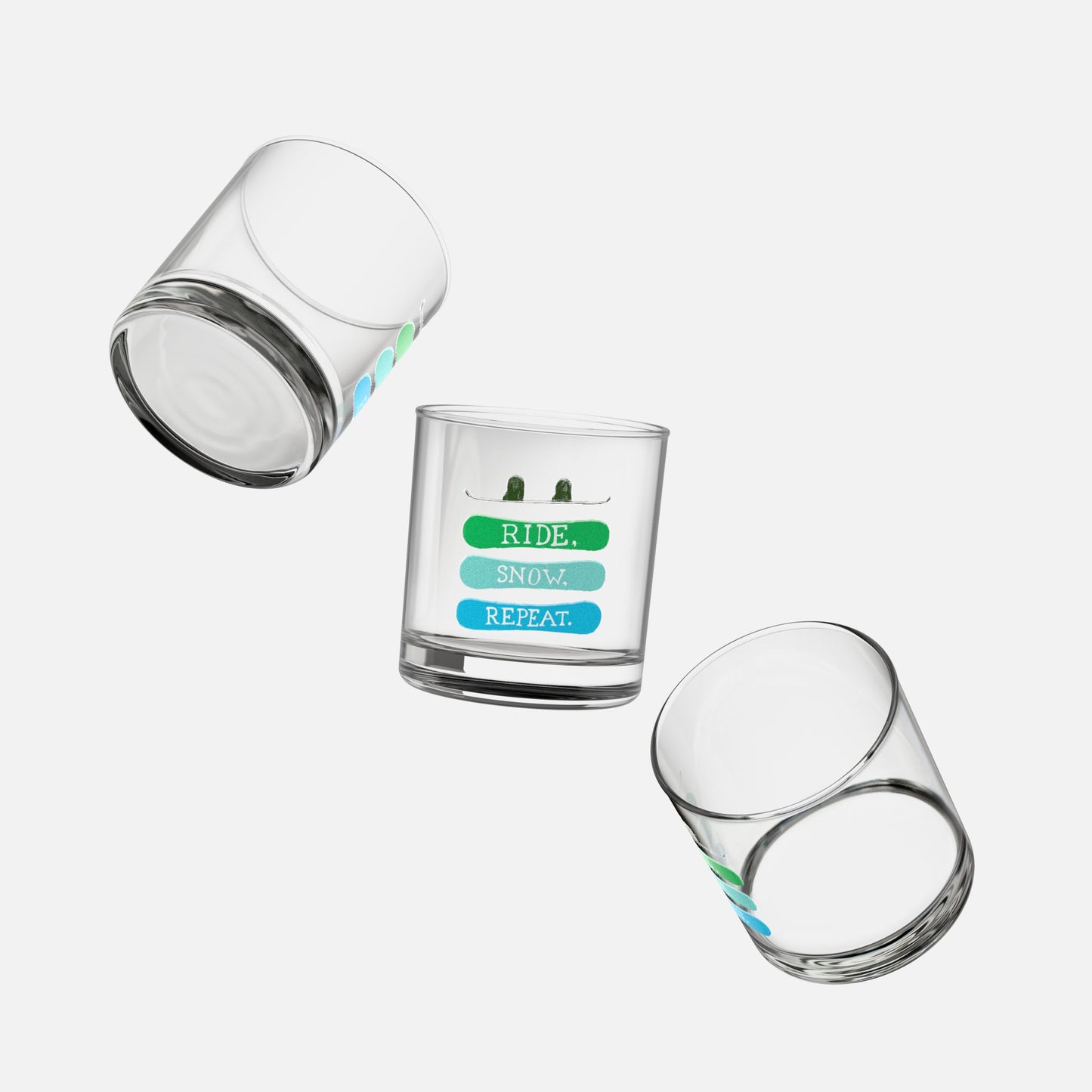 Set of three rocks glasses with the phrase 'Ride, Snow, Repeat' and a snowboarding-themed design, floating on a white background and shown from multiple angles.