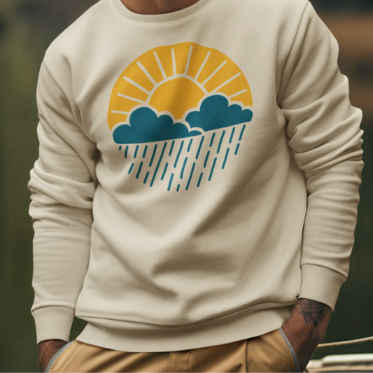 Model wearing the Sun Over Clouds Minimalist Sweatshirt, showcasing a clean blue crewneck with a subtle line illustration of the sun, clouds, and rain in a circular design, styled for casual or outdoor wear.