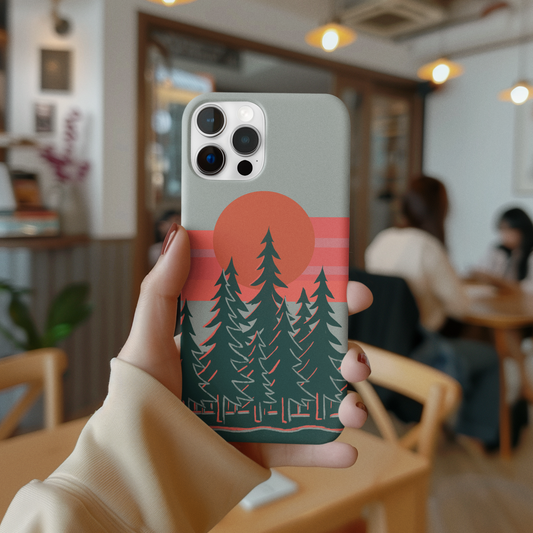 Model holding the Sunset Pines Phone Case in a coffee shop, highlighting the serene sunset and pine tree design.