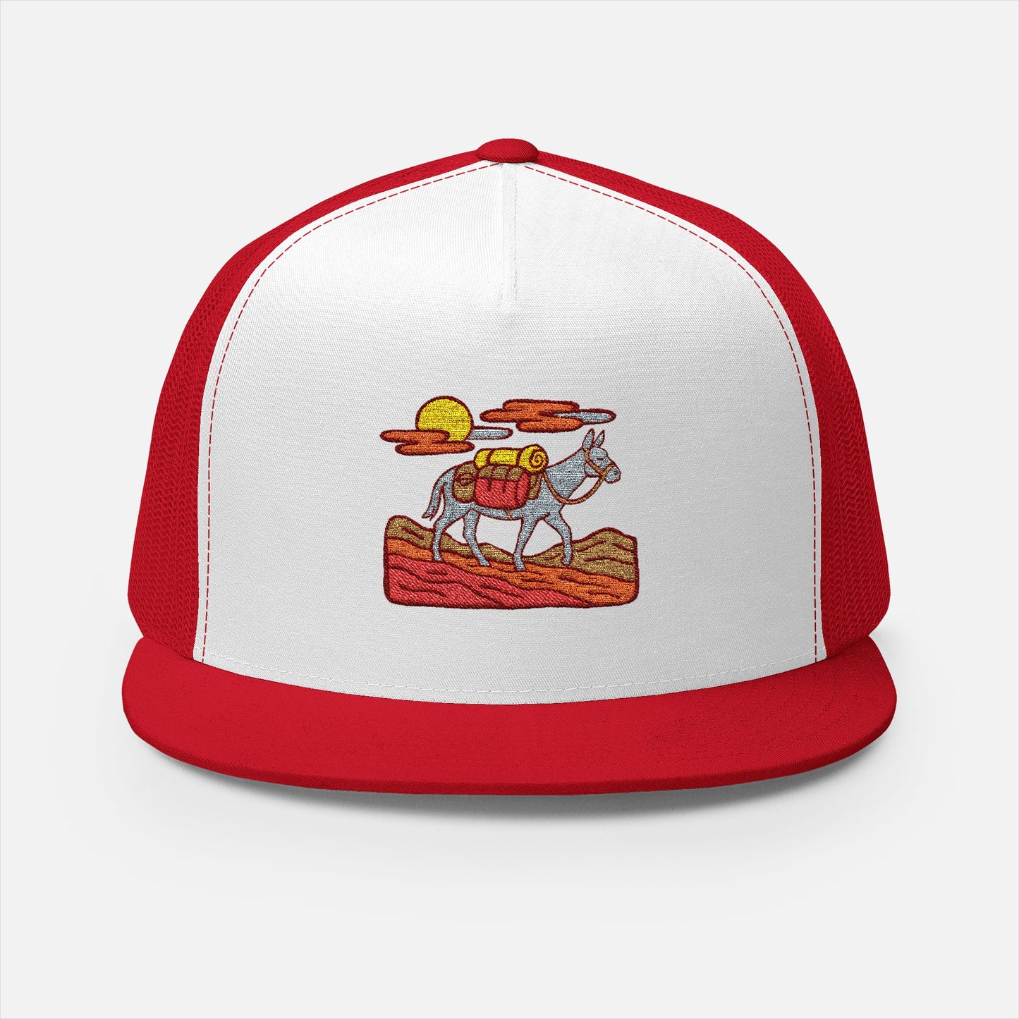 Front view of the Trail Legends Pack Mule Trucker Cap on a white background, featuring an embroidered illustration of a gear-laden pack mule climbing rocky terrain.