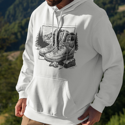 Trek & Trail Hoodie featuring a black ink illustration of hiking boots on a rugged trail, worn by a model for fit and style display. Unique hiking hoodie for Adults by Kempain Family Outfitters.