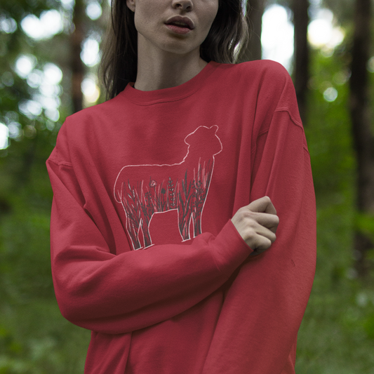 Unisex crewneck sweatshirt worn by model, featuring a sheep silhouette filled with wildflowers for a cozy, nature-inspired look.