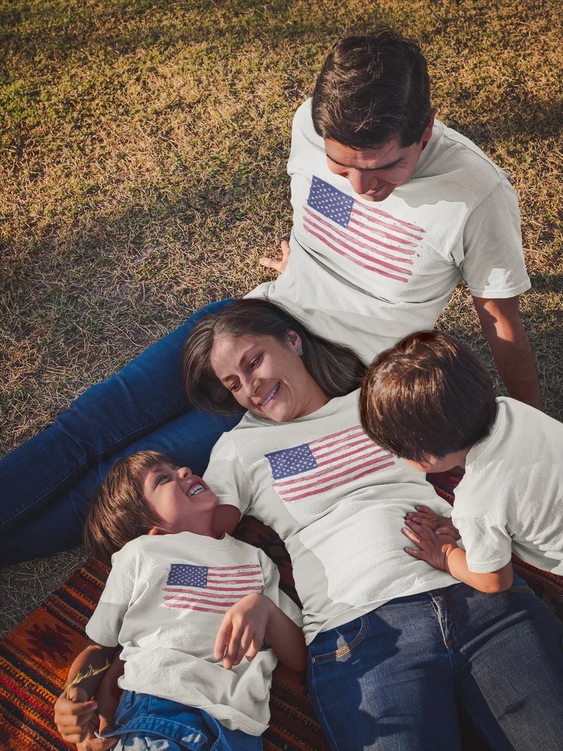 A family wearing matching t-shirts featuring hand-drawn American flag designs, proudly showcasing their patriotism in coordinated style.