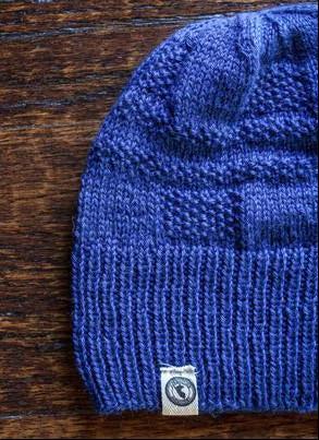 100 percent baby alpaca knit winter hat by Purely Alpaca in Blue color option on a wooden surface.
