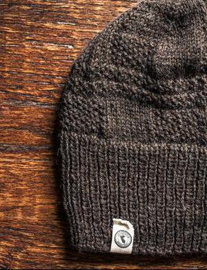 100 percent baby alpaca knit winter hat by Purely Alpaca in Brown color option on a wooden surface.