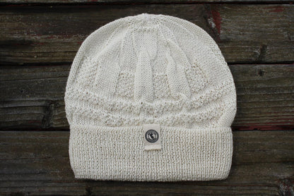 100 percent baby alpaca knit winter hat by Purely Alpaca in Cream color option displayed on a wooden surface.