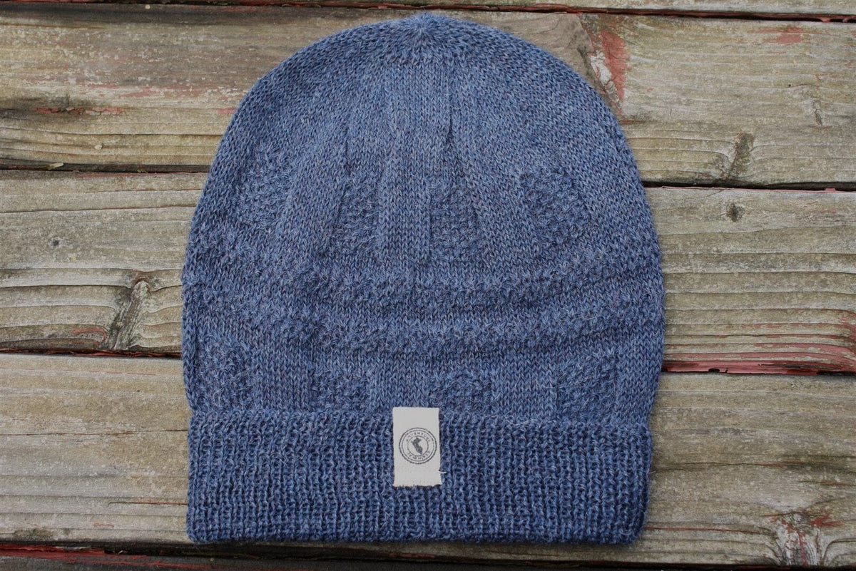 100 percent baby alpaca knit winter hat by Purely Alpaca in Denim color option displayed on a wooden surface.