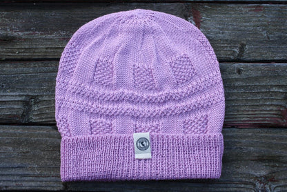 100 percent baby alpaca knit winter hat by Purely Alpaca in Pink color option displayed on a wooden surface.