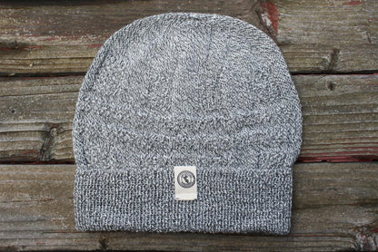 100 percent baby alpaca knit winter hat by Purely Alpaca in Salt and Pepper color option displayed on a wooden surface.