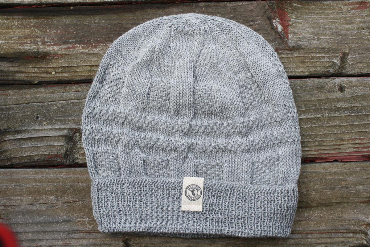 100 percent baby alpaca knit winter hat by Purely Alpaca in Silver color option displayed on a wooden surface.