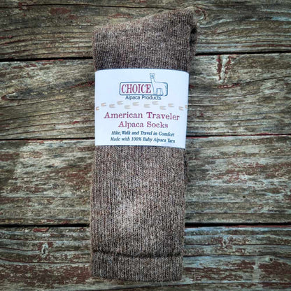 Brown alpaca sock with a label on a wooden surface