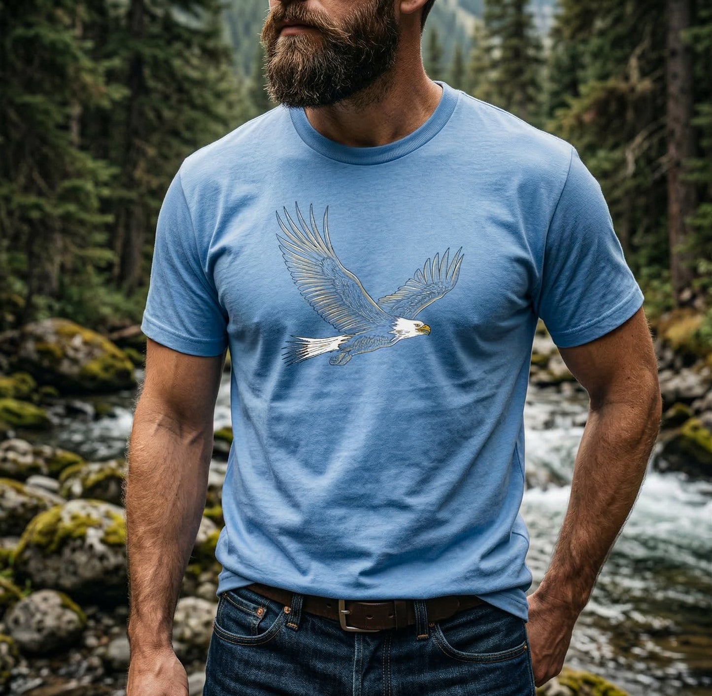 Man wearing a blue t-shirt with an eagle design in a forest setting by Kempain Family Outfitters and original art by Jordan Kempain.