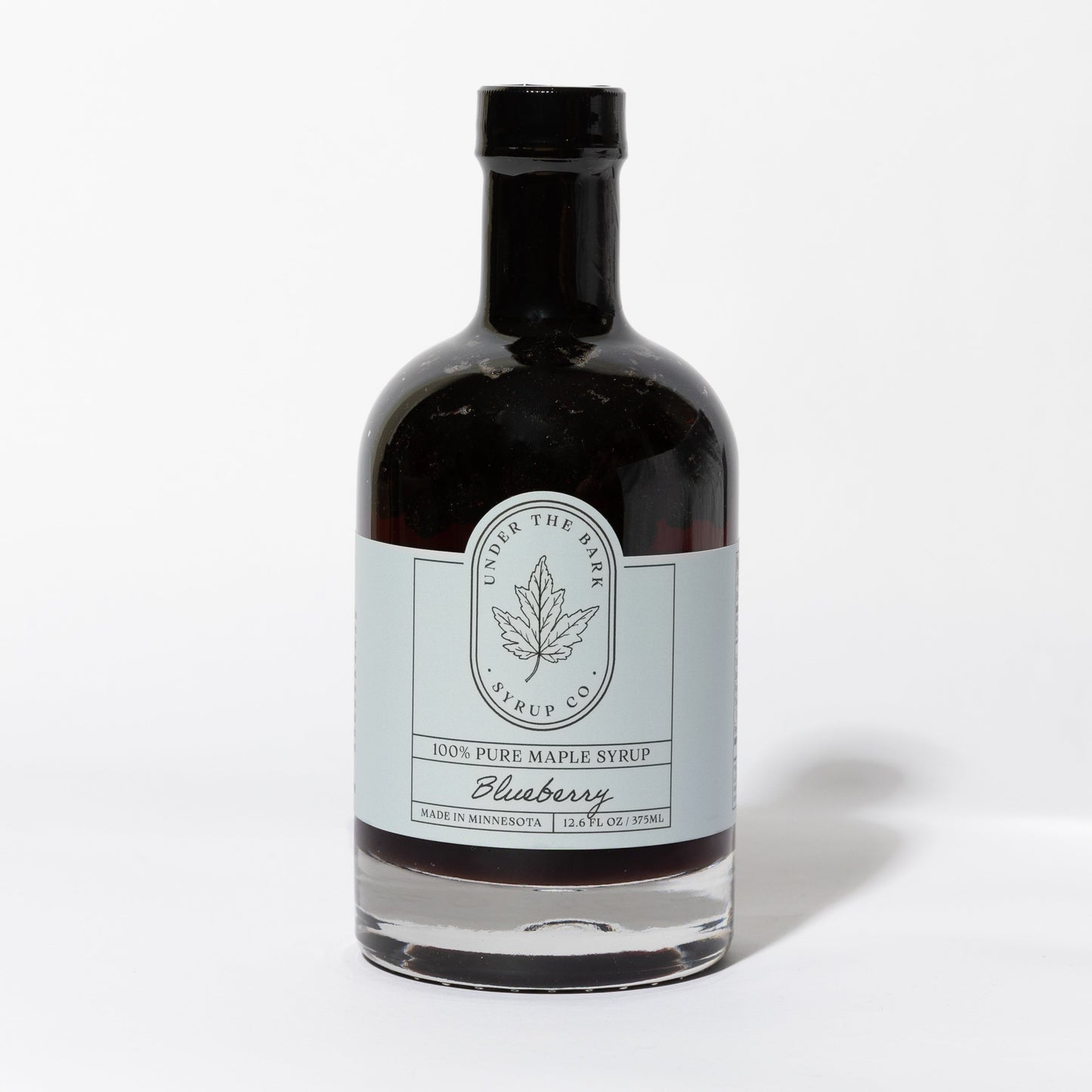 12.6 FL OZ Bottle of blueberry infused 100% pure maple syrup by Under The Bark Syrup Co. on a white background.