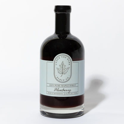 25.2 FL OZ Bottle of blueberry infused 100% pure maple syrup by Under The Bark Syrup Co. on a white background.