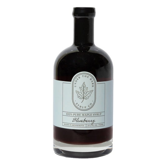 Bottle of Under the Bear Syrup Co. blueberry maple syrup on a white background