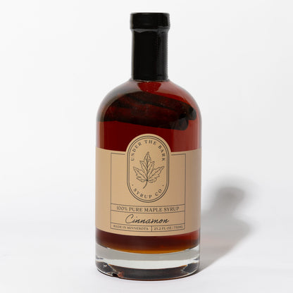 25.2 FL OZ Bottle of cinnamon-flavored 100% pure maple syrup by Under The Bark Syrup Co. on a white background.