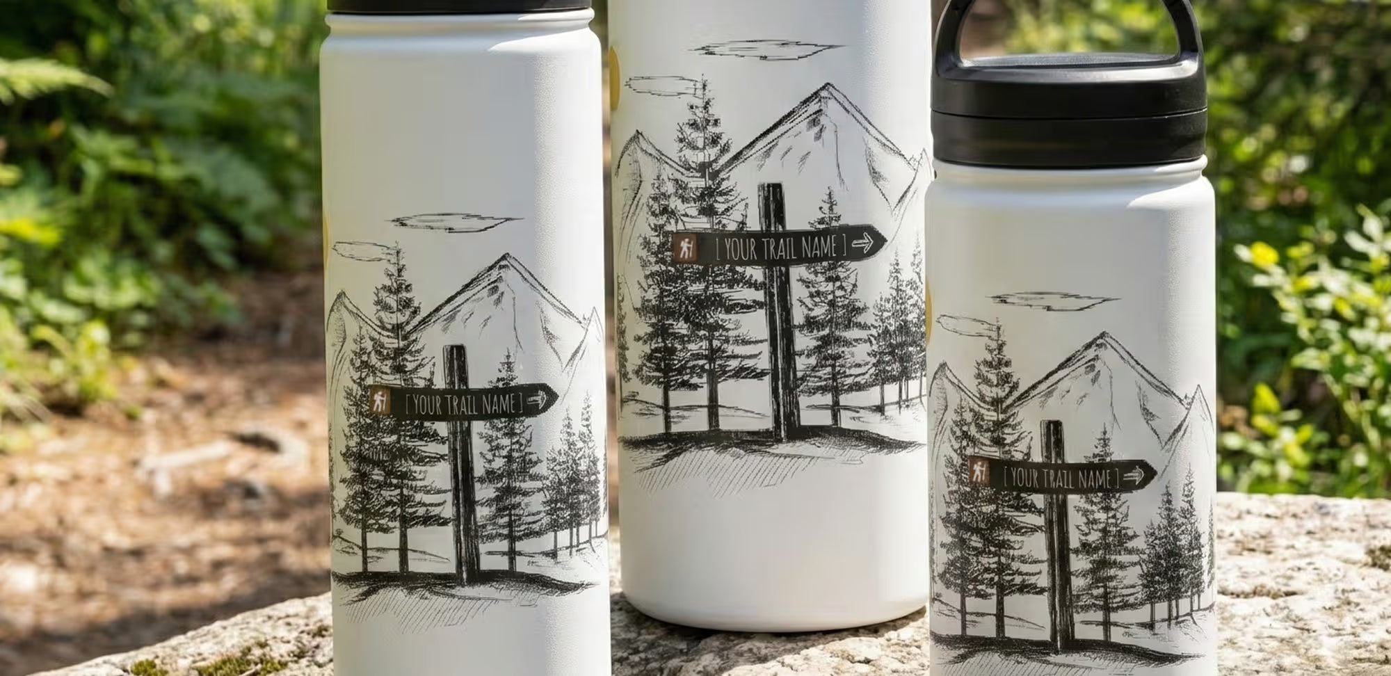 Three custom white tumblers with black illustrations of hiking signs and trees on a natural background.