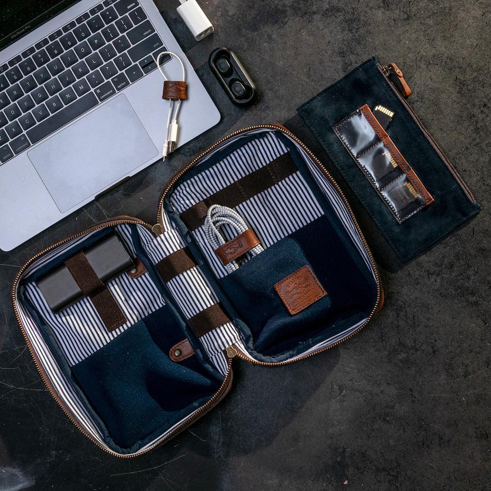 Full-Grain Leather Electronics / Toiletry Organizer displayed open near computer showing compartments for cords and memory cards.