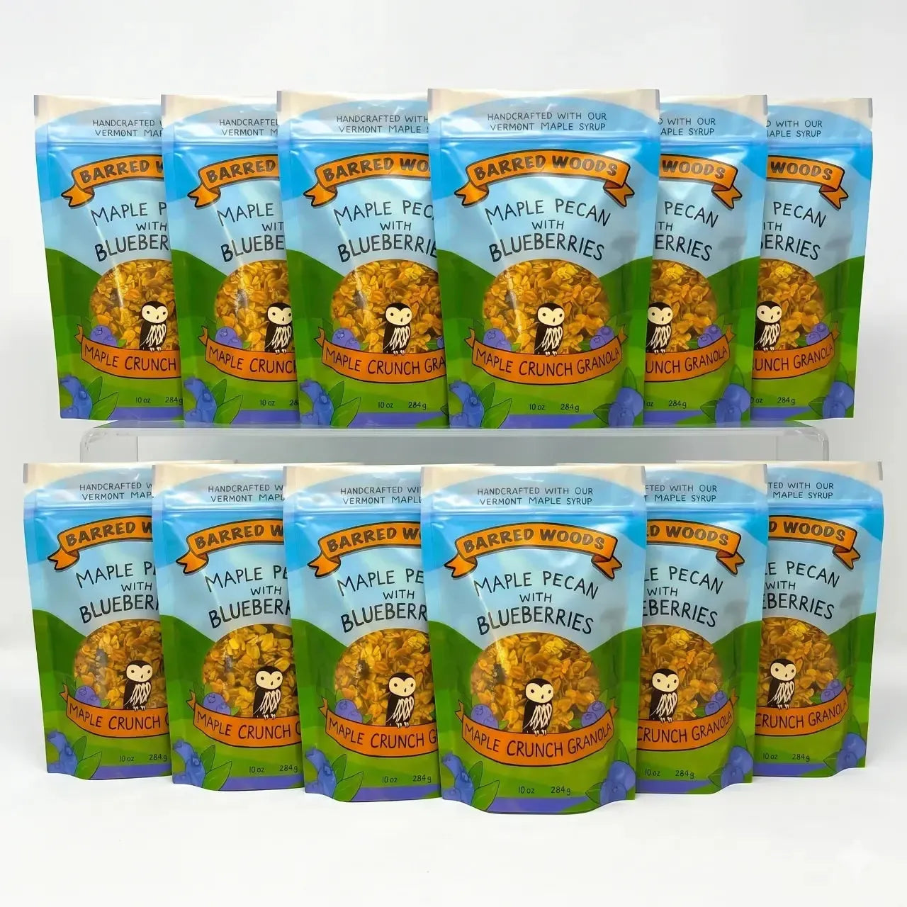 12 packages of Barred Woods Maple Pecan with Blueberries Crunch Granola on a white background