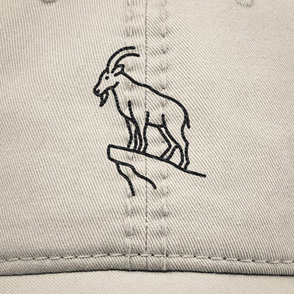 Close up of beige dad hat with black goat illustration embroidered on a beige cotton.