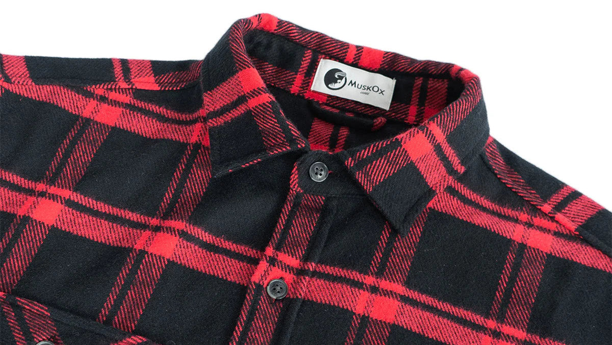 Close-up of a black and red plaid shirt with a brand label on a white background