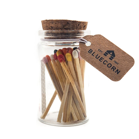 Jar of matches with a cork lid and Bluecorn tag on a white background