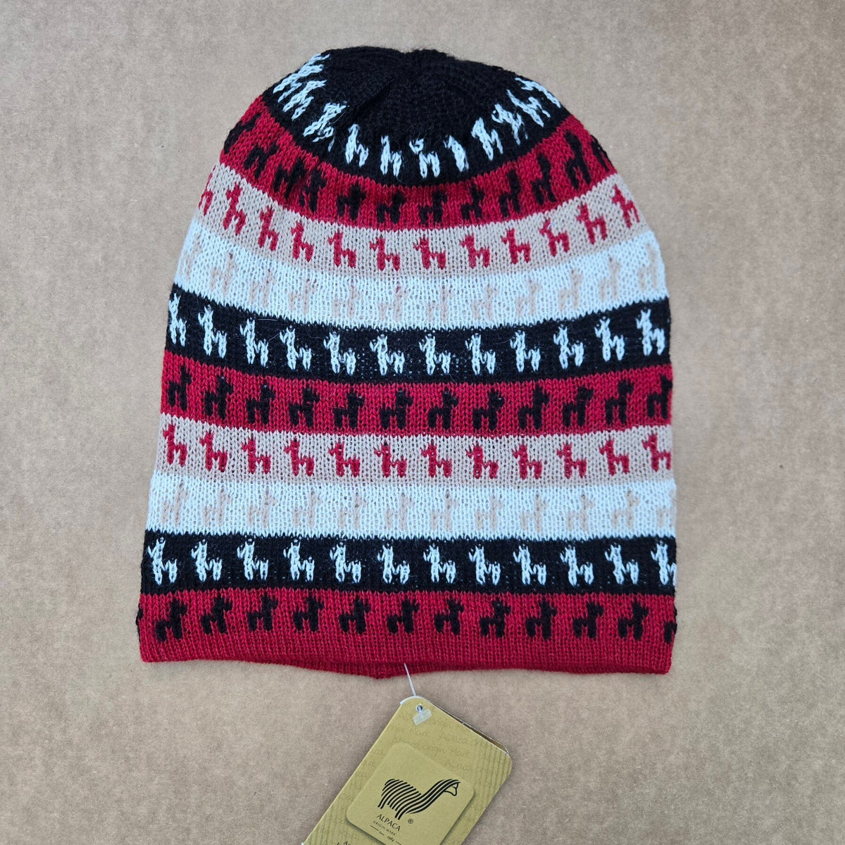 Knitted beanie with Alpaca pattern on a beige background